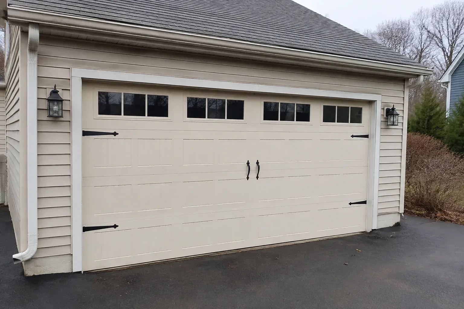 Cream carriage-house-style garage door with dark decorative hardware. — Carriage-House Garage Door Installation, Markham
