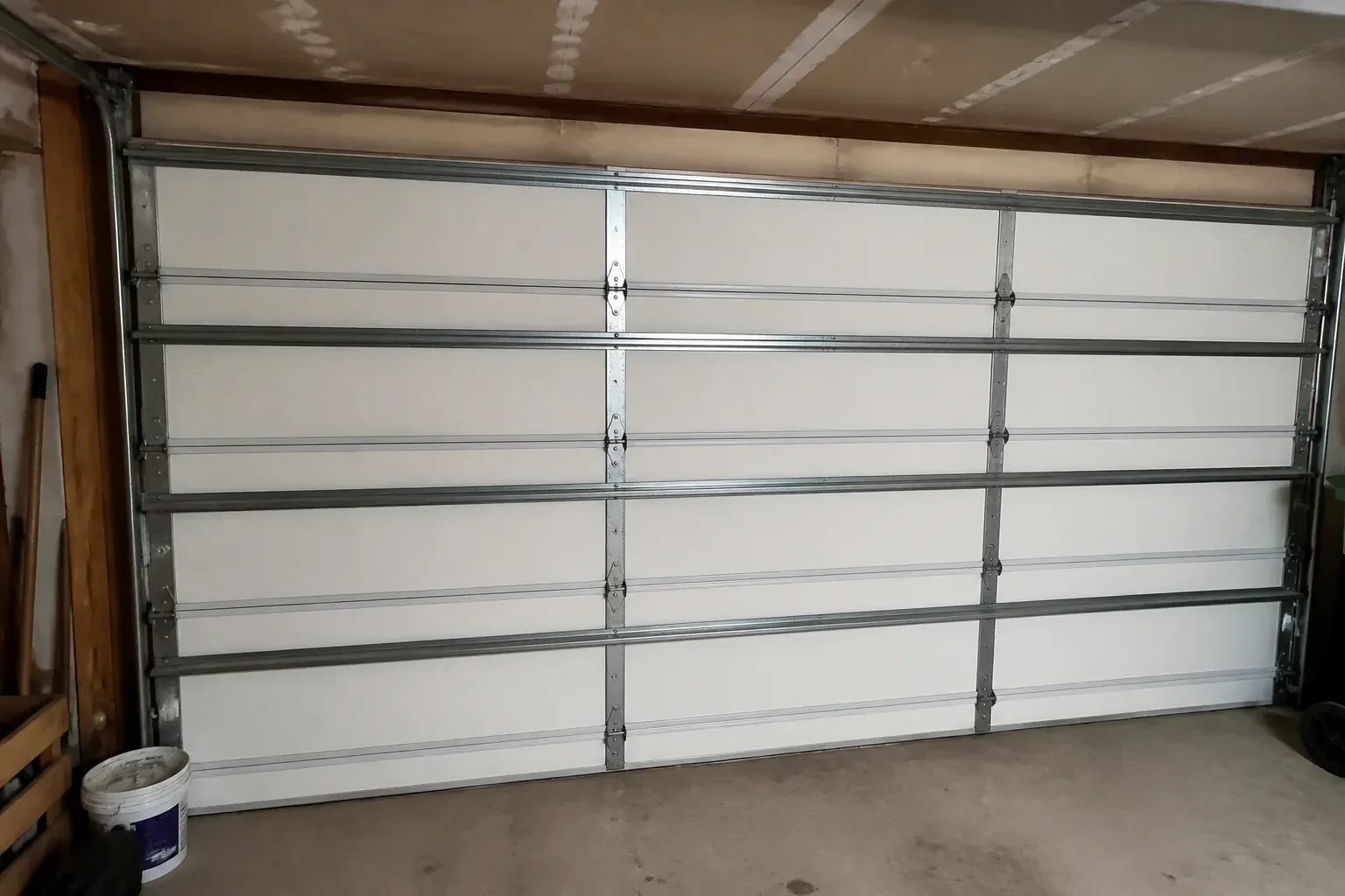 Interior of a closed sectional door with horizontal metal reinforcement struts. — Wind-Rated Garage Door Replacement, Markham